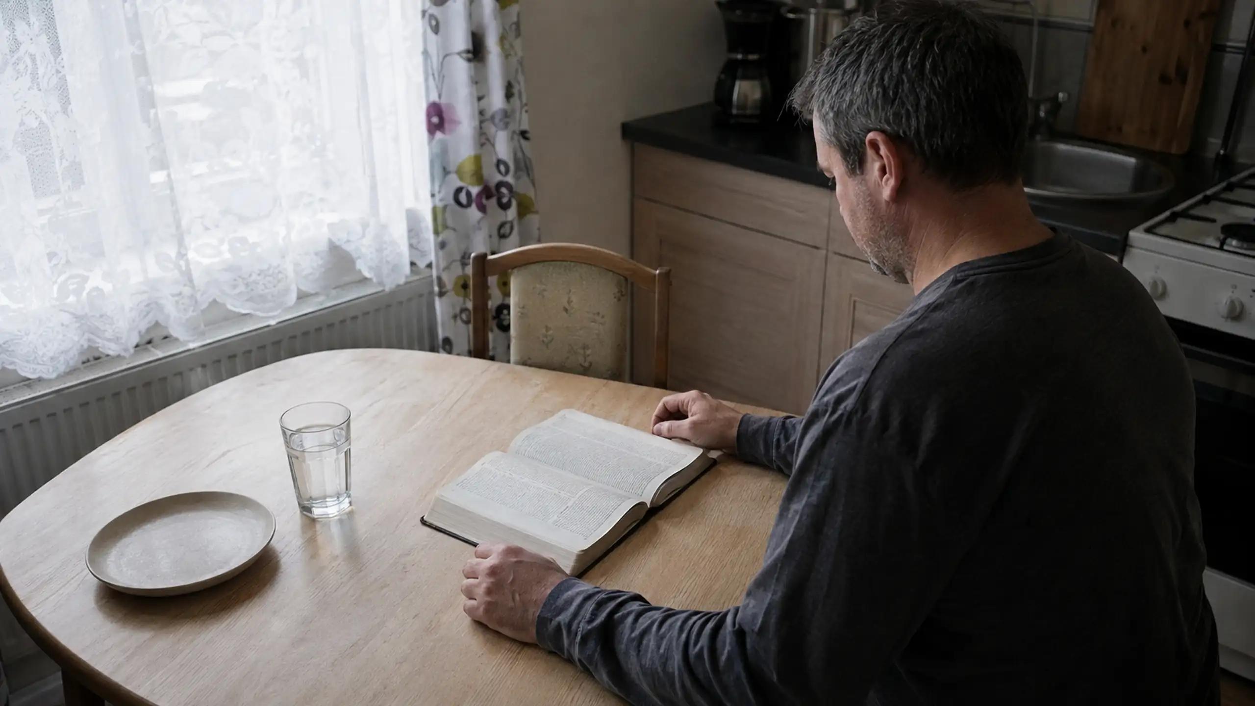 Možno v kuchyni za stolom sa modliť a číta bibliu